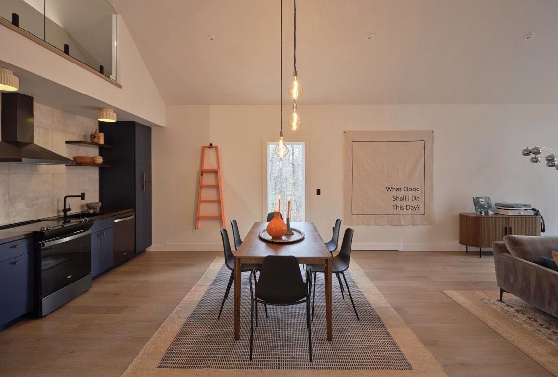 Dining area beneath pendant lights with a view to the loft