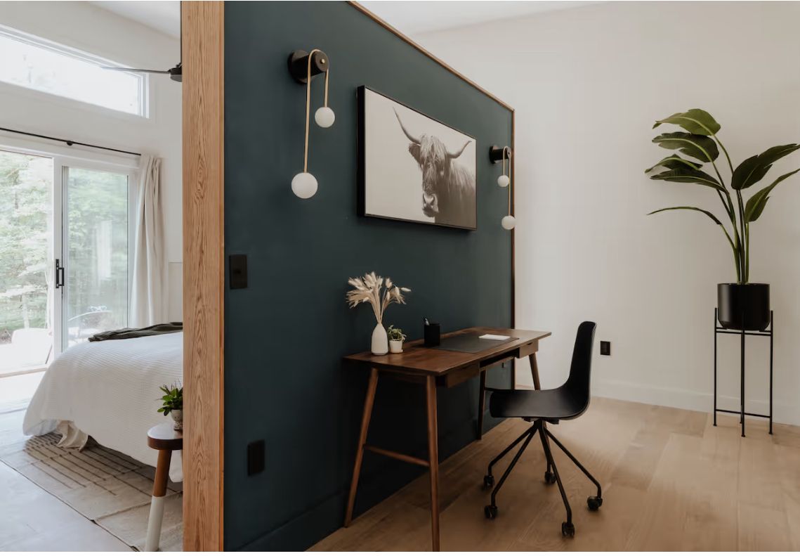 Deep green study nook with desk and wall sconce