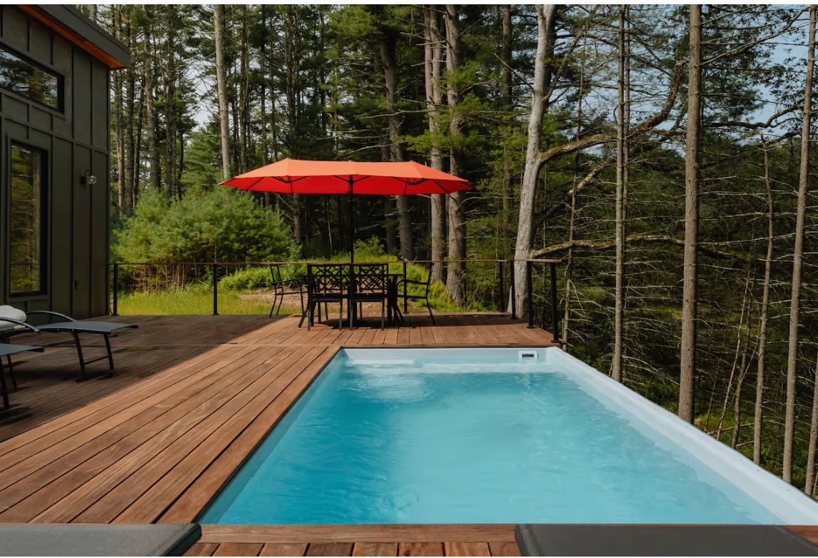Deck and pool with red umbrella and dining table