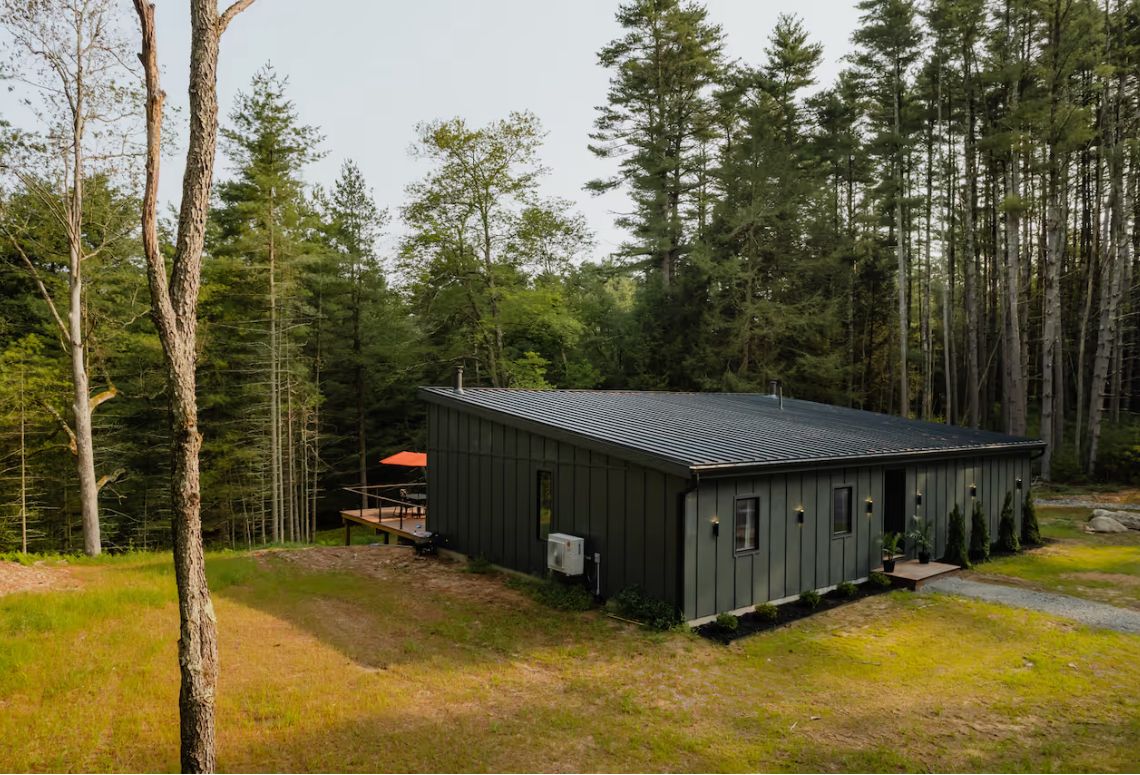 Sun-bleached deck and plunge pool at White Pines, seen from the tree line
