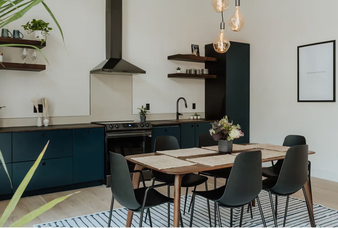 Navy kitchen with open shelving and a dining table